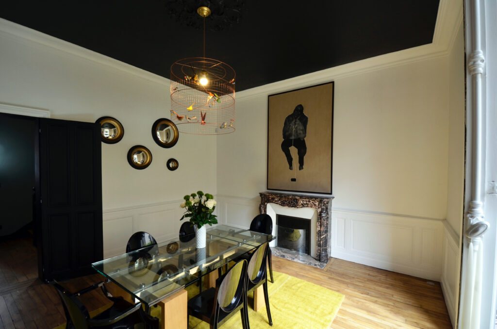 salle à manger avec tapis, suspension oiseaux, miroirs ronds sur le mur et cheminée, architecture d'intérieur Rennes, D'un Lieu à L'autre